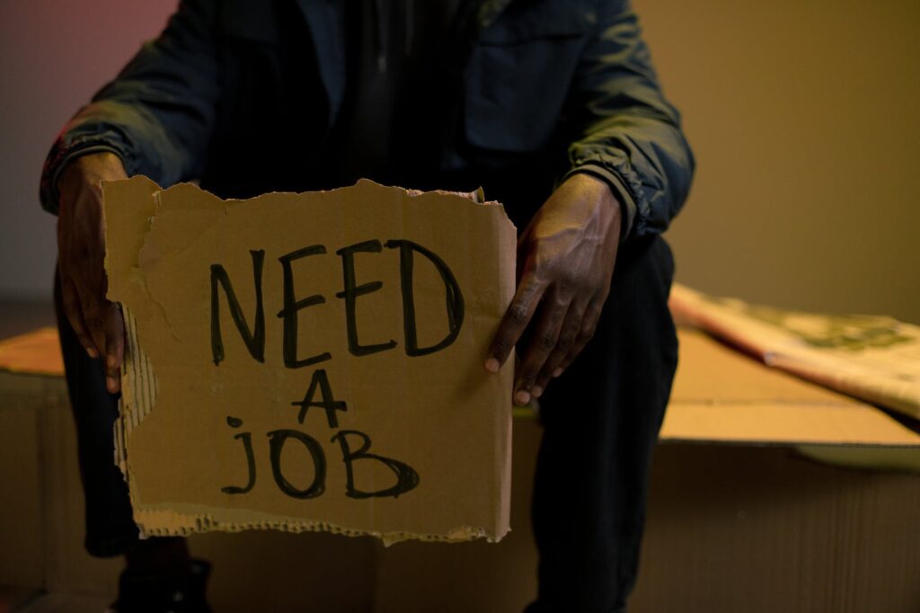 homeless man holding cardboard in hands